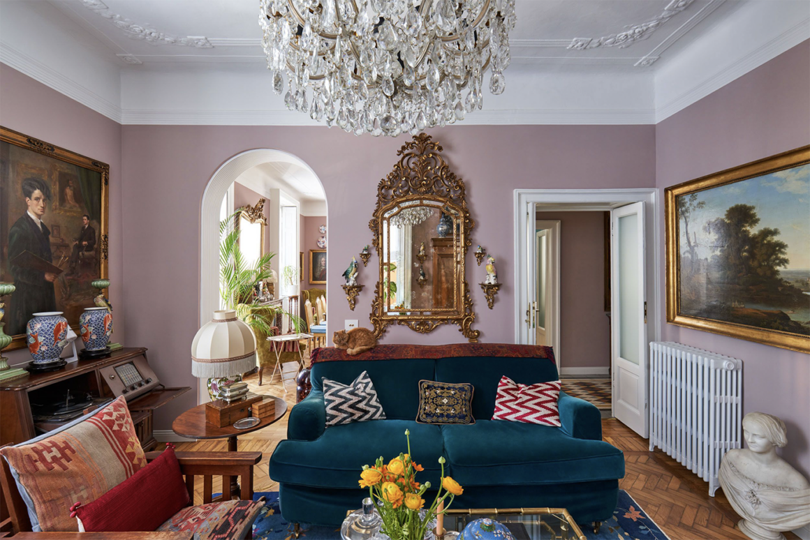eclectic designed living room with pink walls and crystal chandelier.
