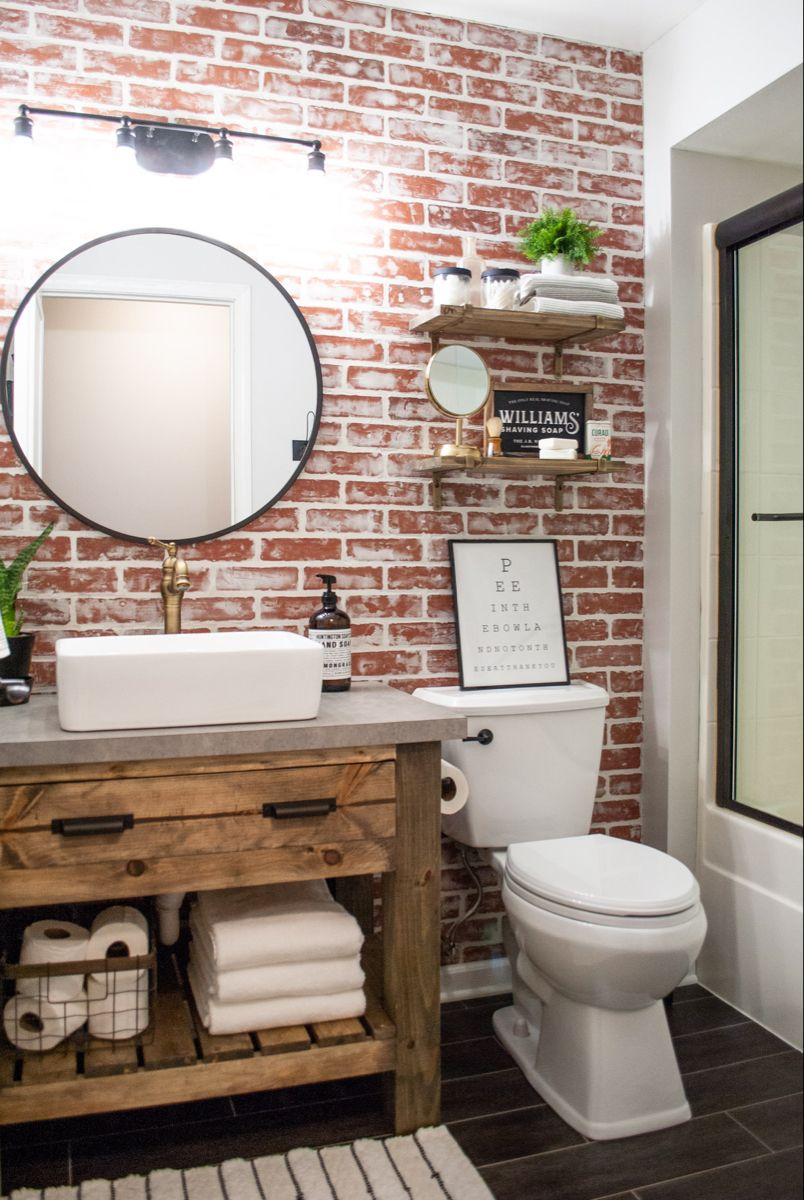 brick wall bathroom with sustainable tile floors and white toilet 